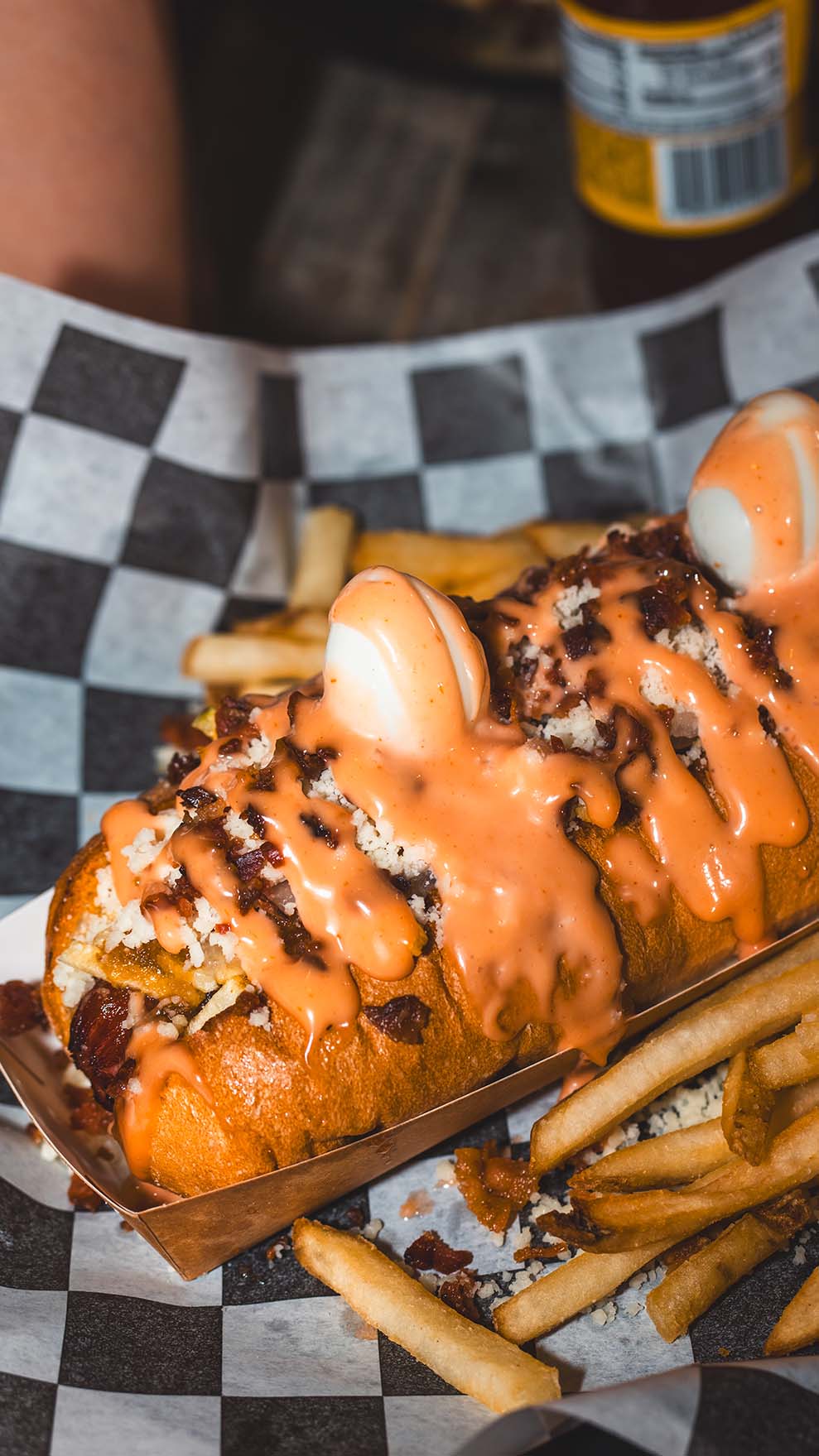 Loaded hot dog finished with bacon, cheese, and signature sauce.