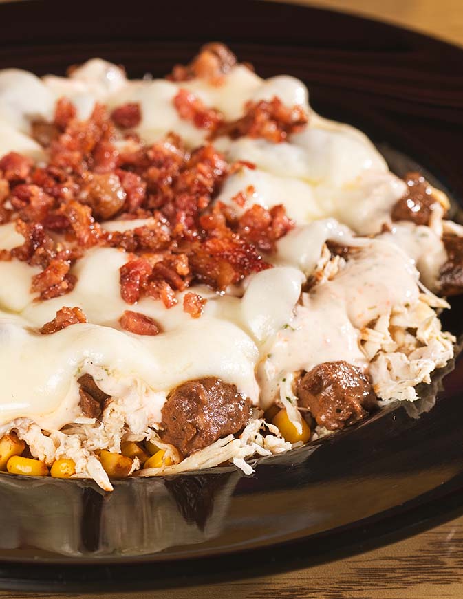 Cheesy loaded chicken and beef plate finished with crisp bacon.