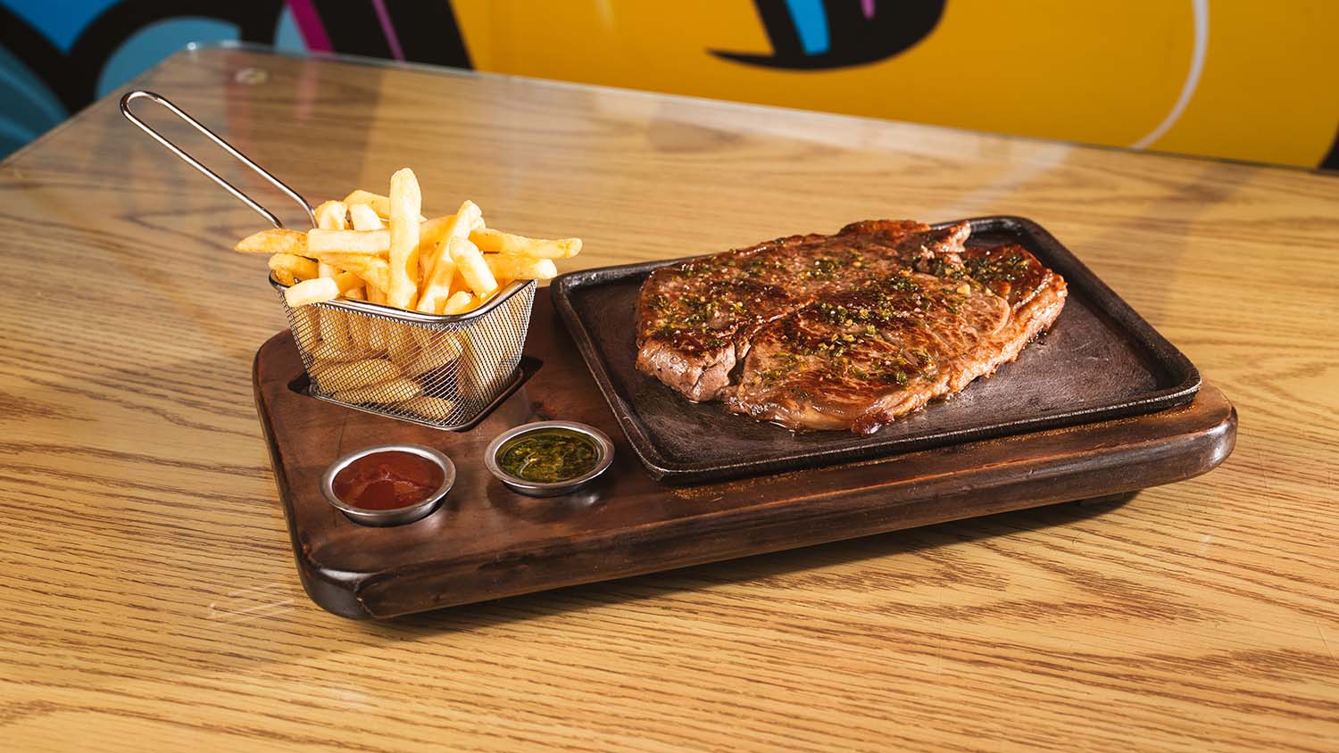 Grilled steak and fries presented on a sizzling restaurant board.