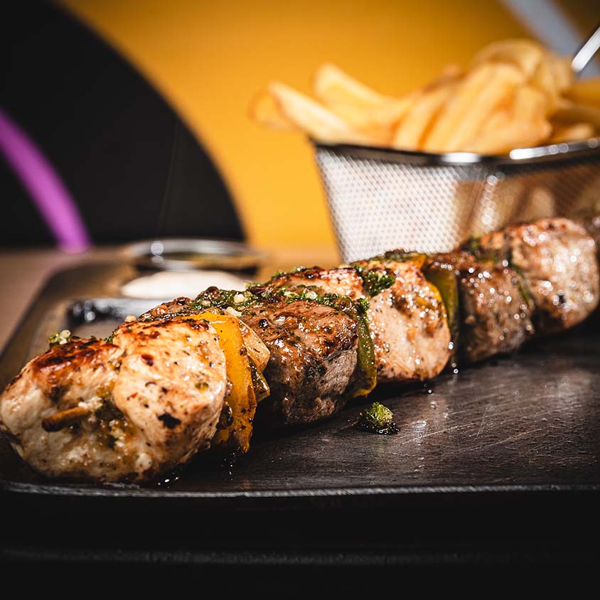 Grilled steak and chicken skewers served with crisp fries.