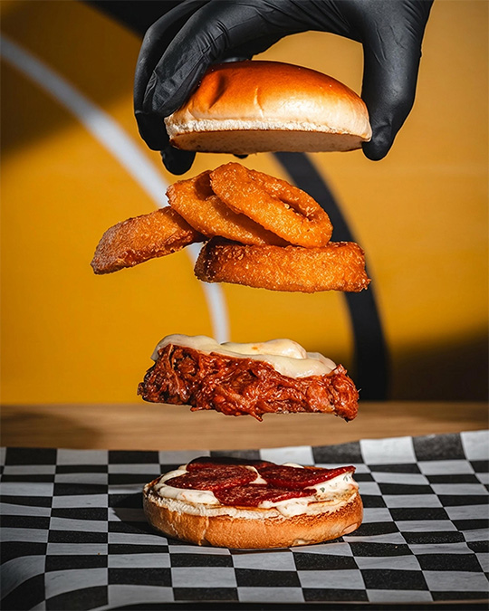 Deconstructed burger ingredients suspended in a playful advertising composition.